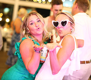 Two women playfully posing with heart-shaped glasses at a lively event, capturing a candid moment of fun and celebration, reflecting the authentic, unposed style of Awesnap's event photography.