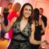 Woman dancing joyfully at an event, surrounded by guests in a lively atmosphere, showcasing the energy and emotion captured in photography.